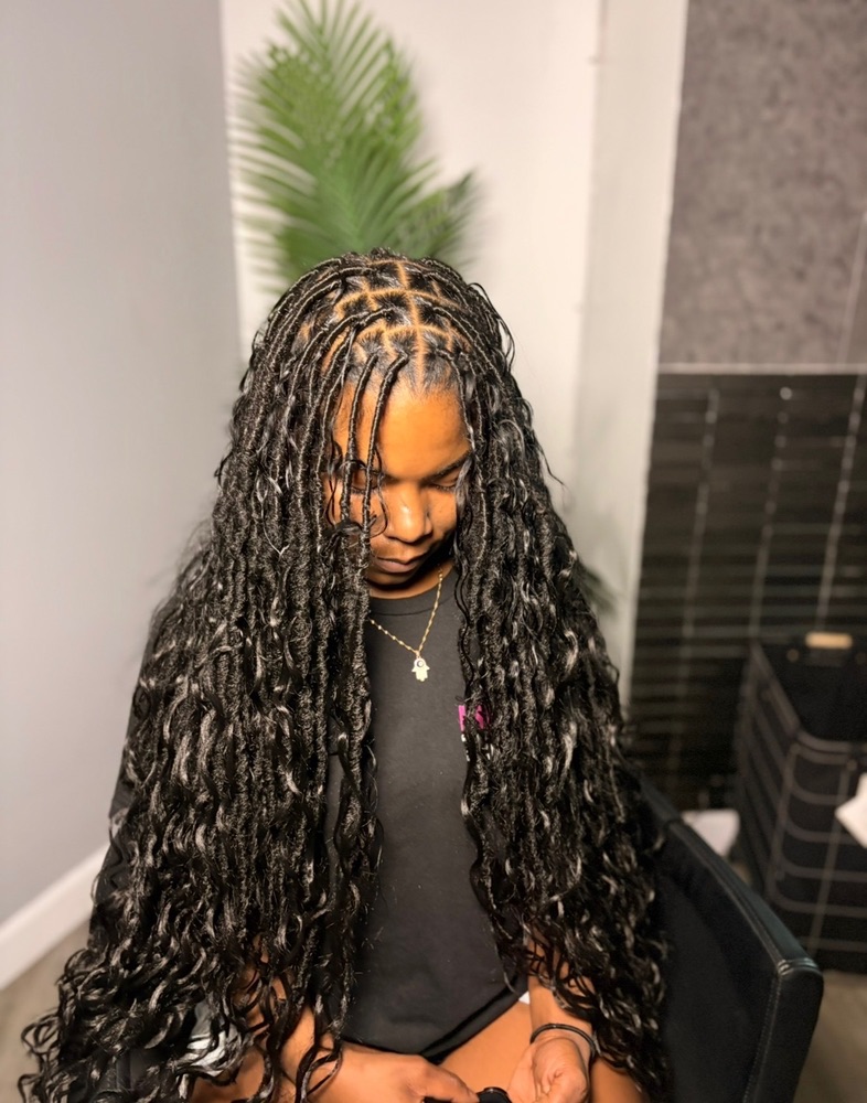 Red ombre knotless braids with boho curly ends, client seated in salon chair